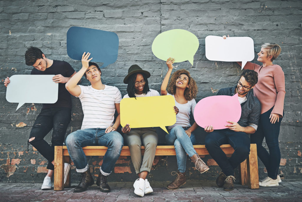 Kommunikation ist wichtig - Personen auf der Bank, die Sprechblasen hochhalten